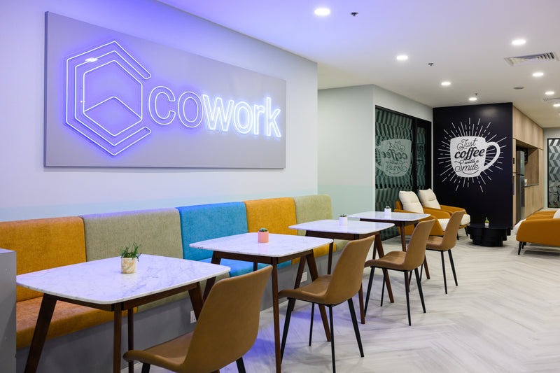 Underneath our CoWork sign, the hot-desking area has a colourful, wall-mounted sofa. Convenient electrical points are beneath the sofa for easy charging.