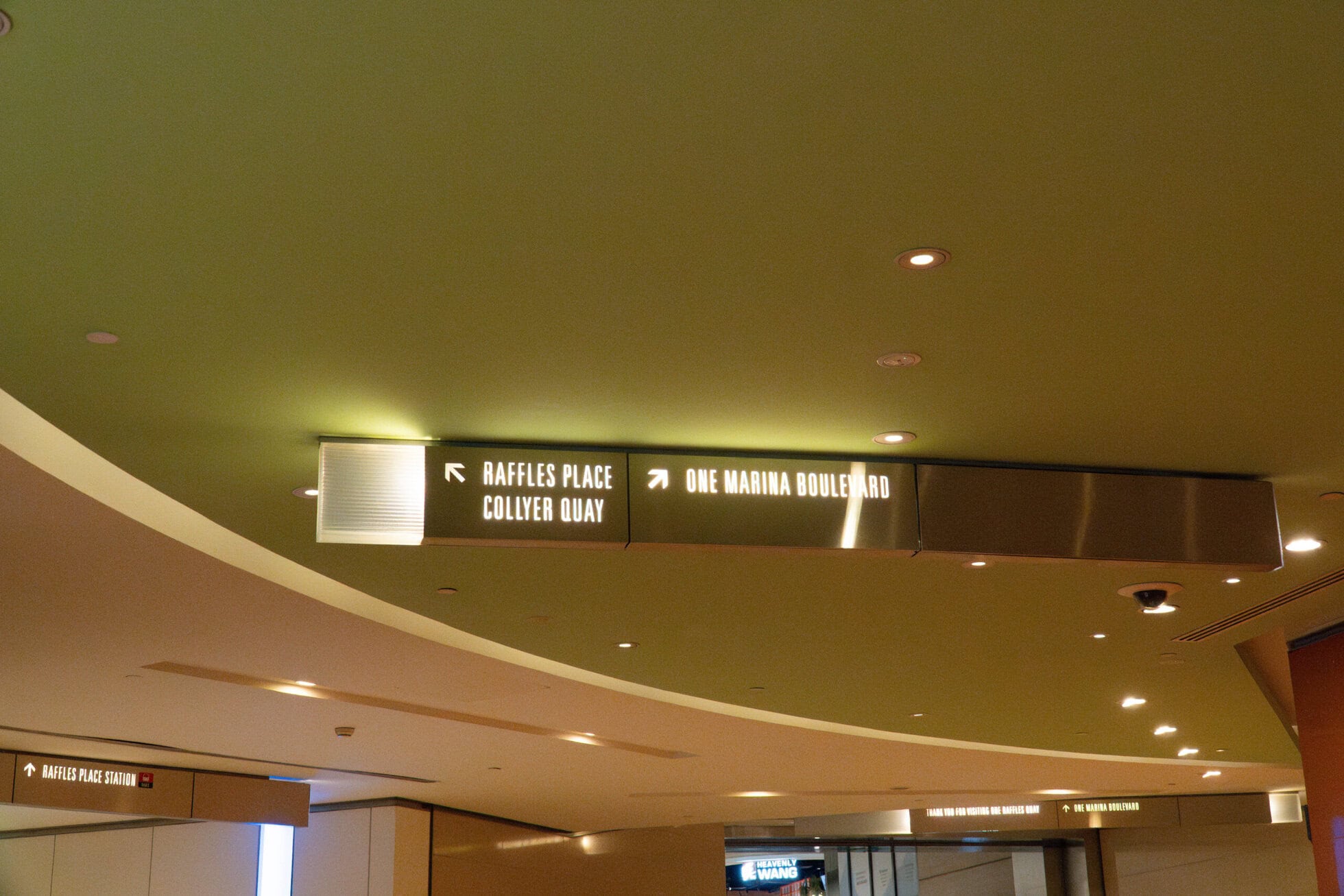 Getting to 6 Raffles Quay in the Rain Signage directing to Raffles Place and One Marina Boulevard in Singapore.