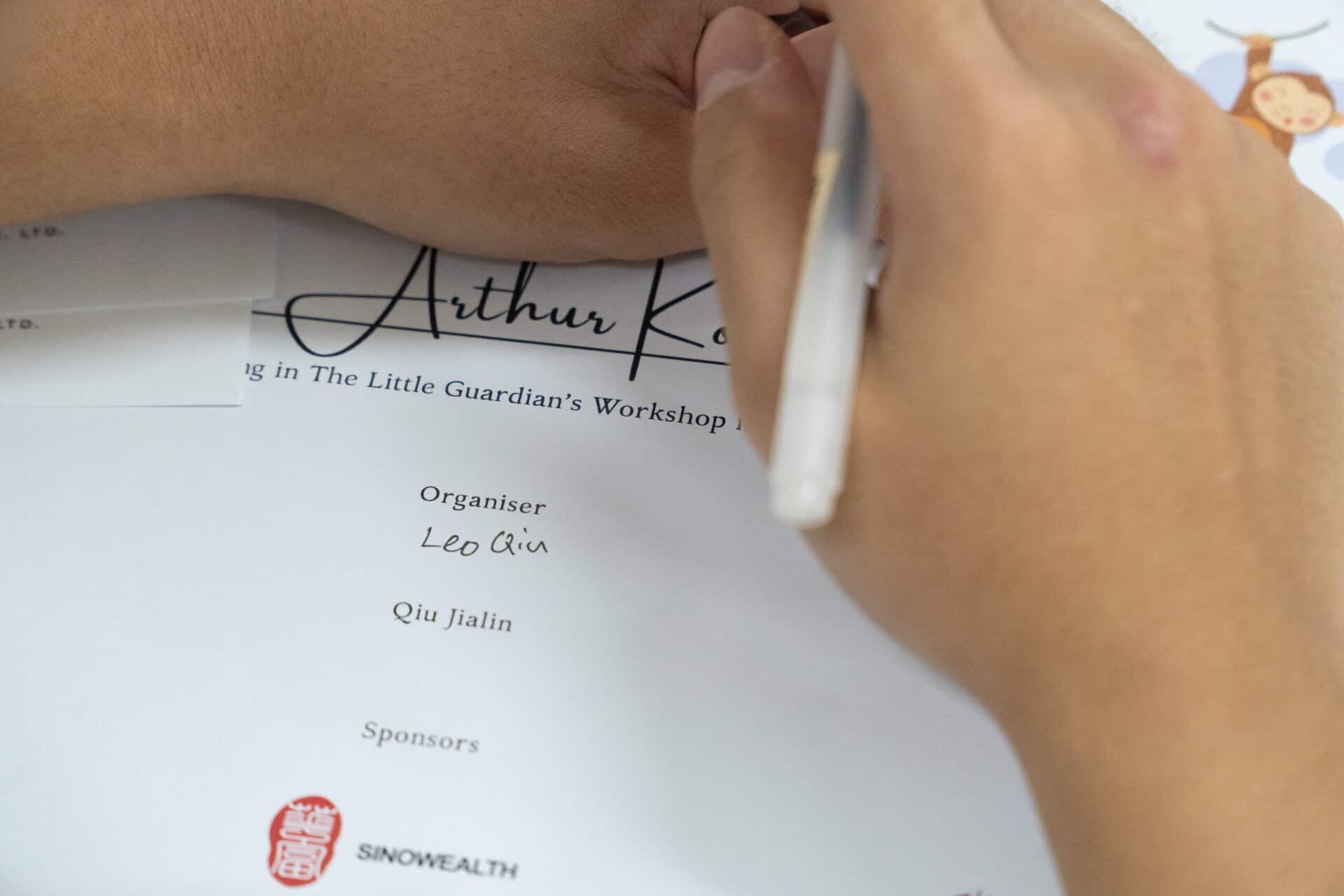 Child signing a certificate at the Ecosystem Awareness Workshop for children.