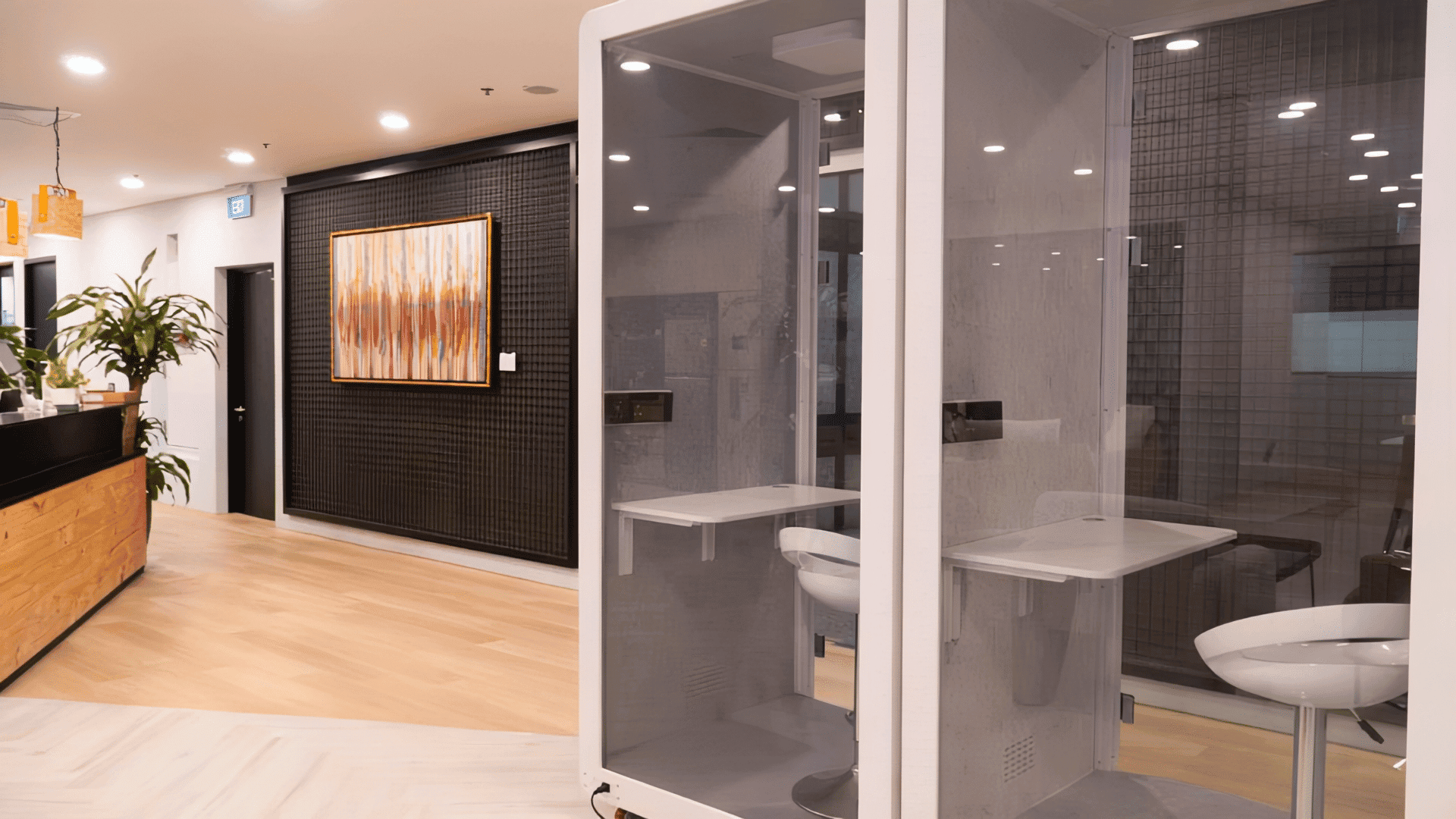 Modern coworking space reception area with private phone booths. Private phone booths in a modern coworking space for focused work.