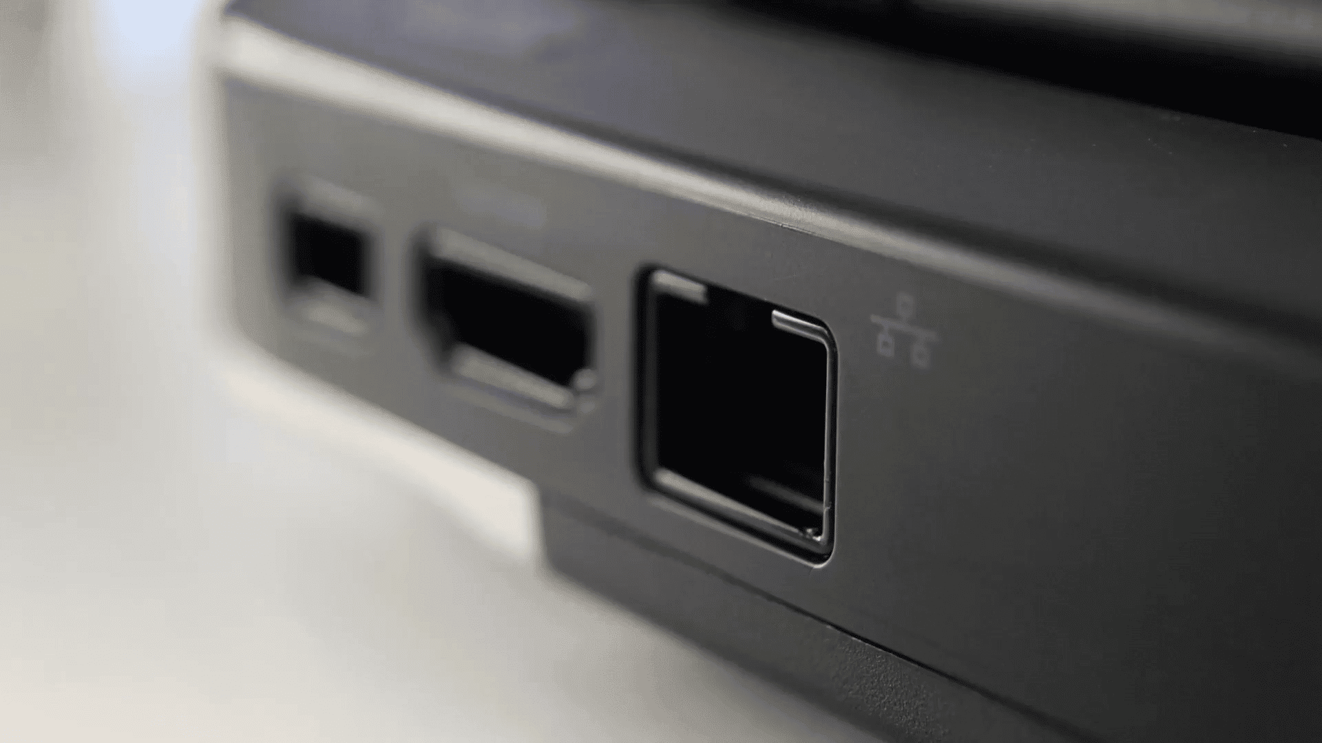 A close-up of a laptop port and USB slots in a contemporary coworking environment.