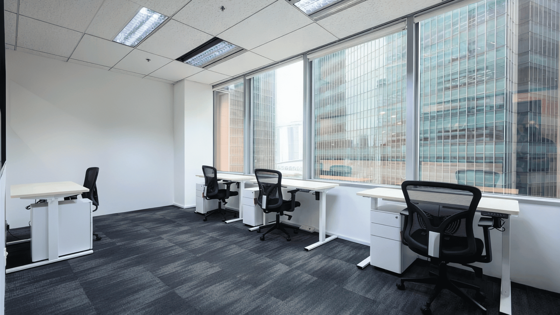 Office workspace with large windows and ergonomic chairs for productivity.