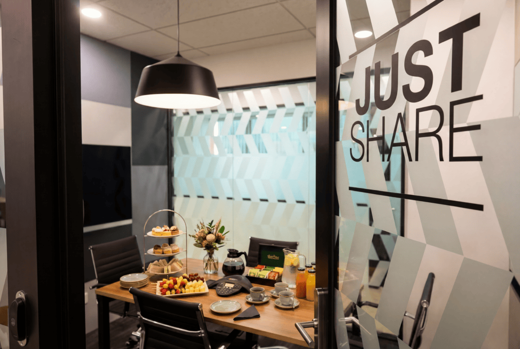 Modern coworking meeting room with refreshments and decor.