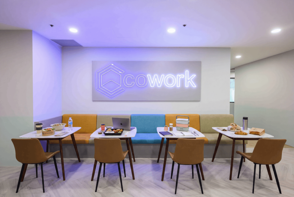 Modern coworking space with seating and meeting tables for collaboration.