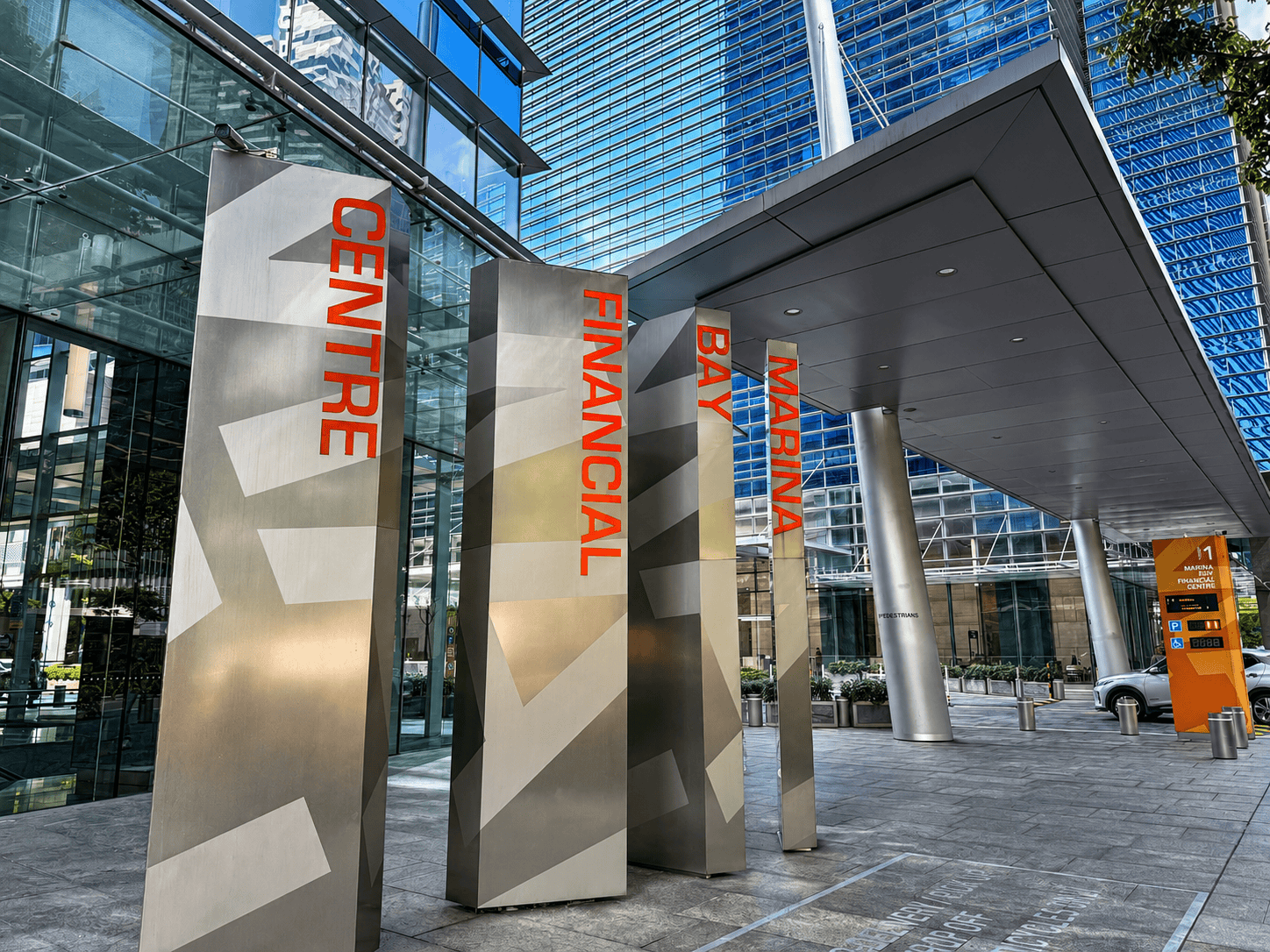 Marina Bay Financial Centre Modern office building entrance with signage for Centre, Financial, Bay, and Marina areas.