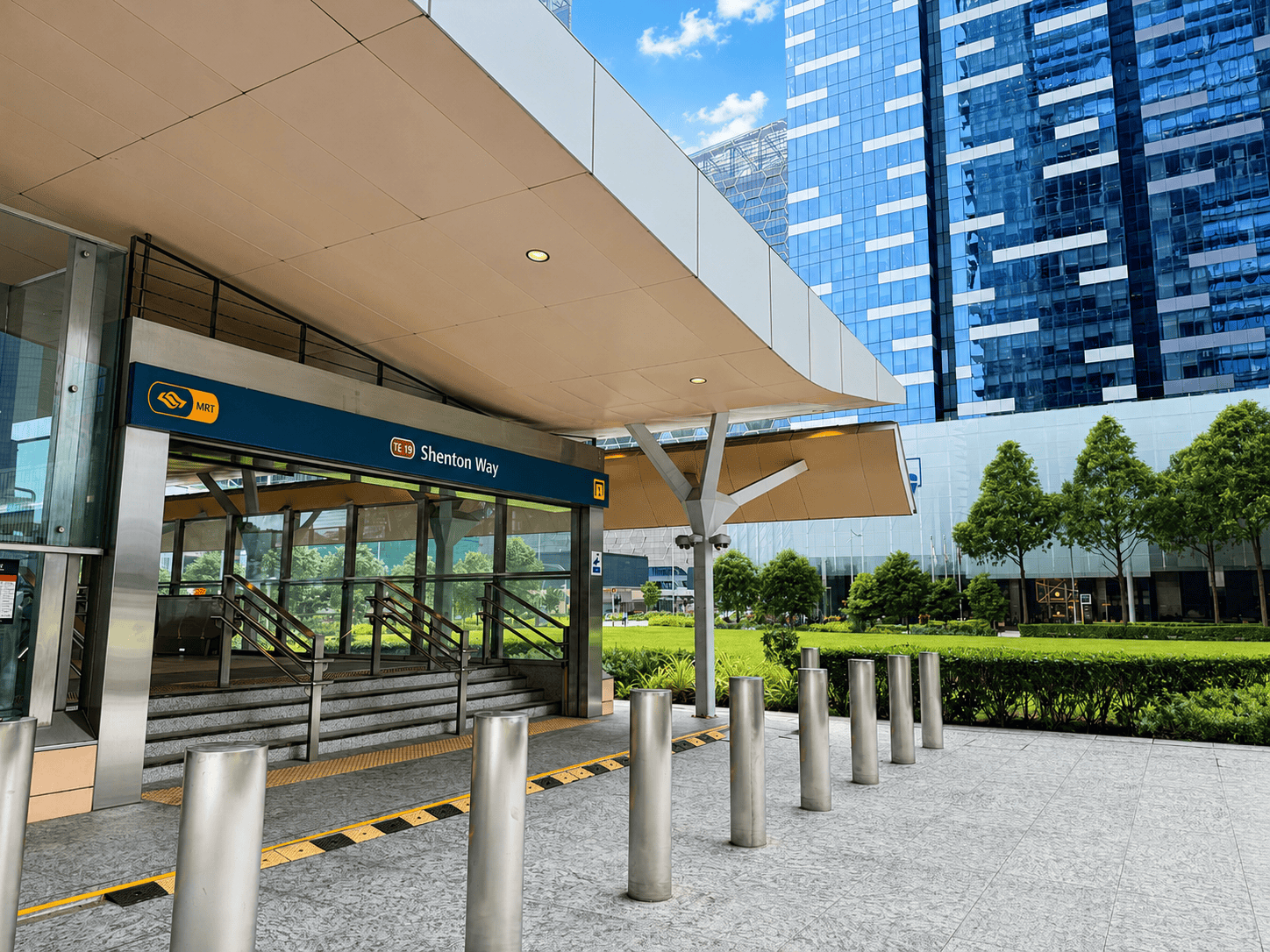 Shenton Way MRT-1 Shenton Way MRT station entrance in Singapore with modern architecture and greenery.