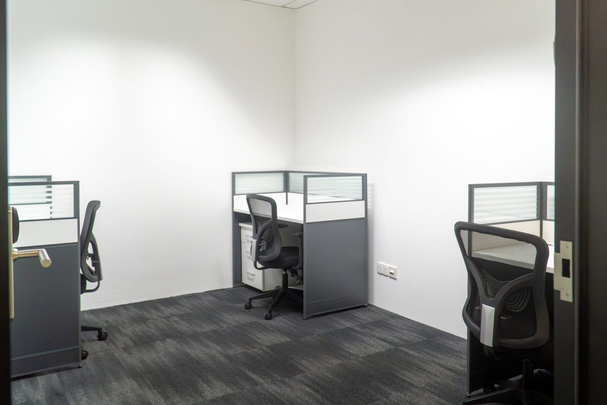 Modern CoWorking Office Space in Singapore Empty co-working cubicles with ergonomic chairs in a bright office.