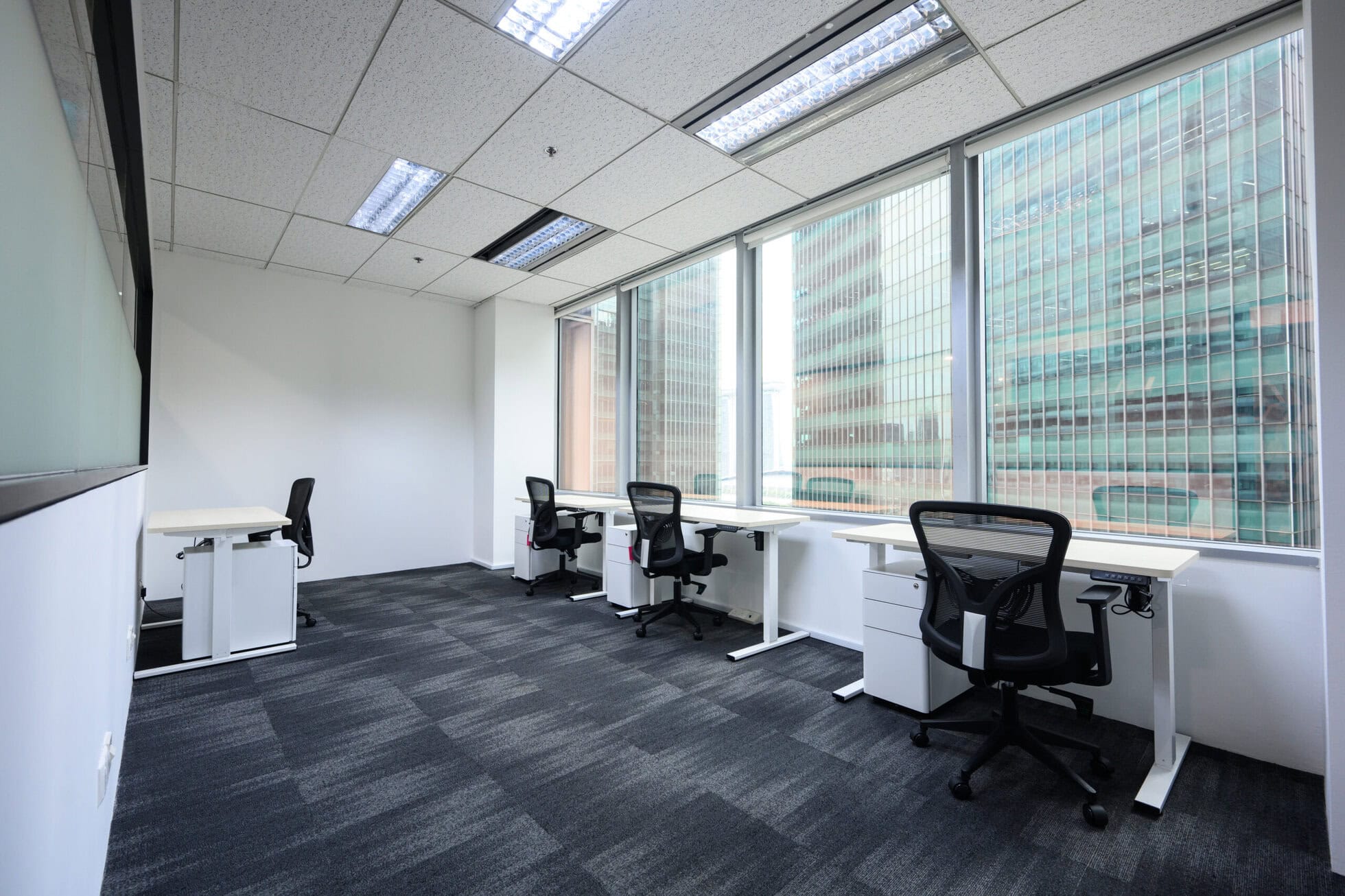 Bright co-working office with large windows and ergonomic chairs.